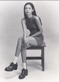 a black and white photo of a woman sitting on a chair